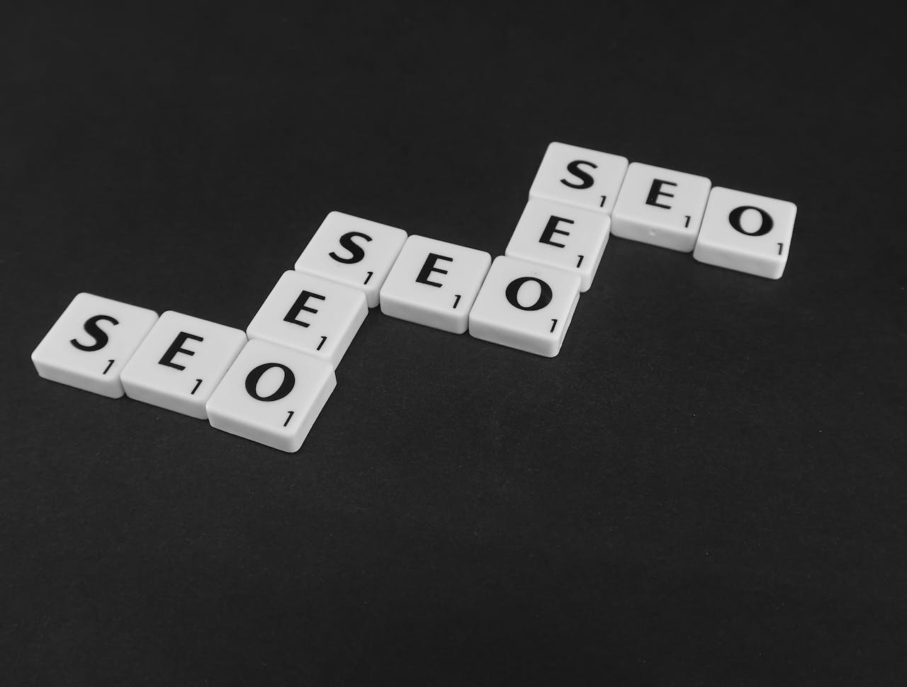 services-03 SEO spelled with Scrabble tiles on a black surface, representing search engine optimization concepts.